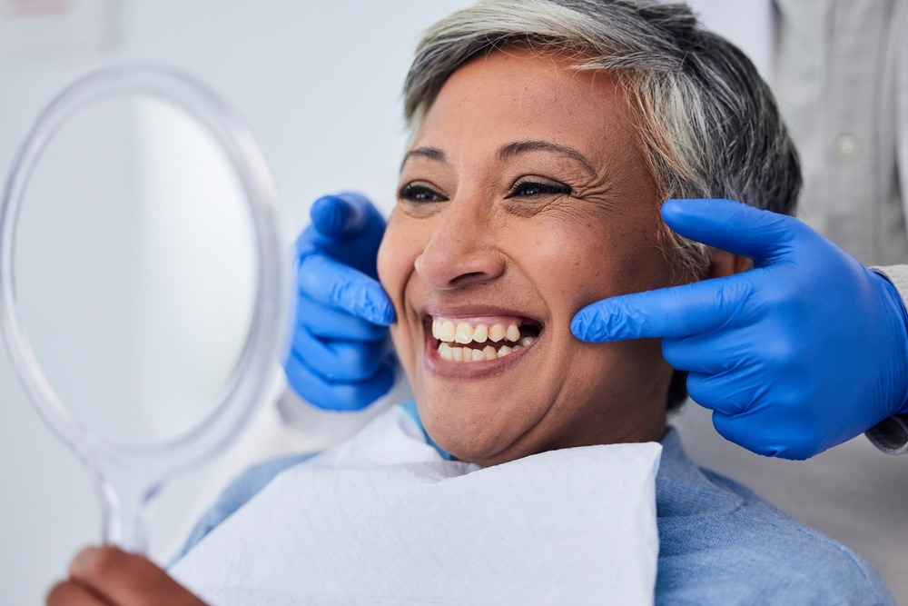 Dentist showing an older woman her bright, clean smile after her professional teeth cleaning.